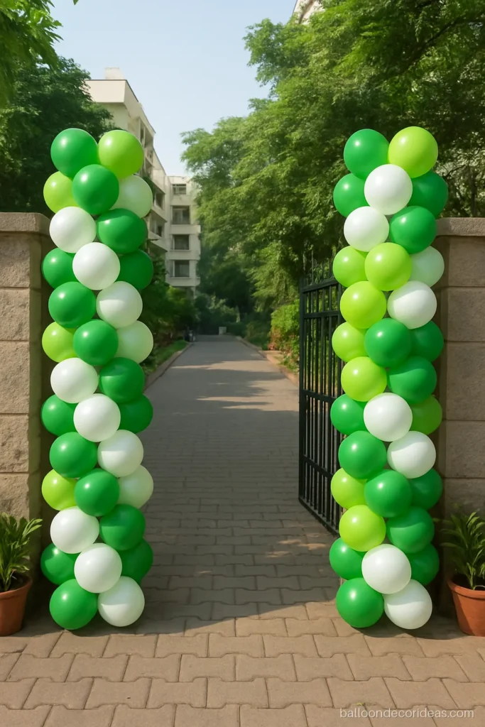 Gate balloon decoration with green and white columns on both pillars of a society entrance
